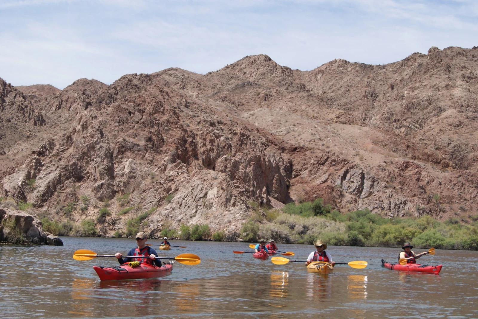 Two kayakers paddling on clear Emerald Cave water