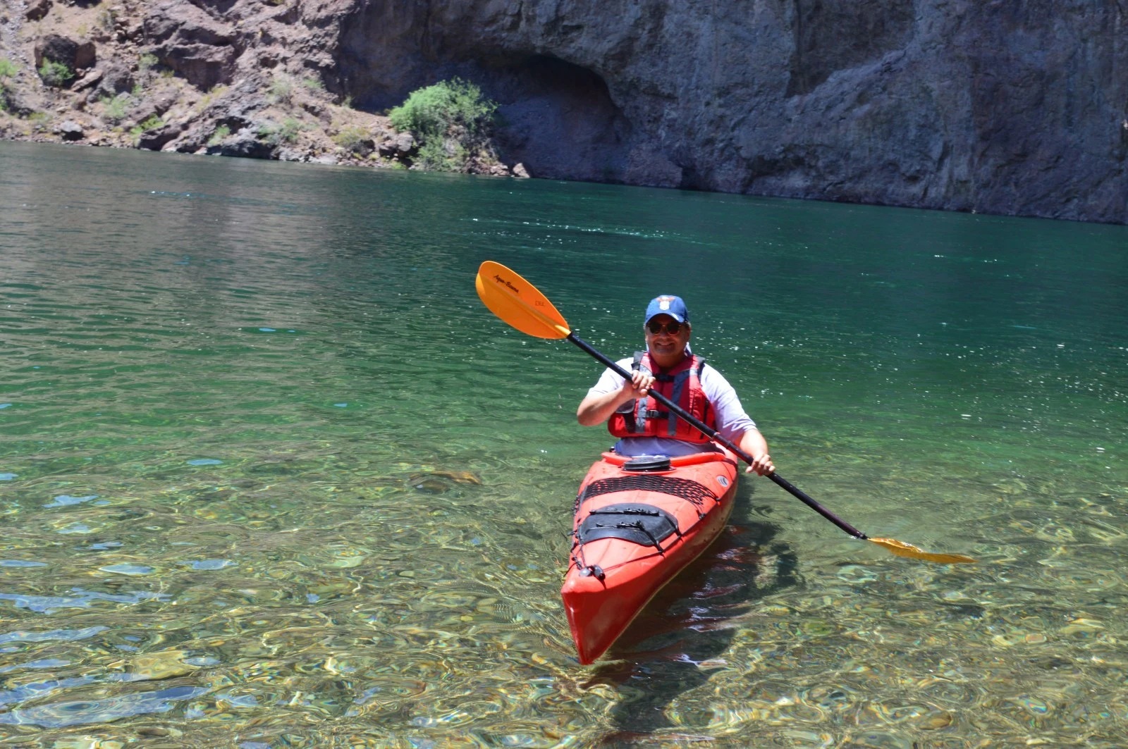 A kayaker paddling on emerald green water during an Evolution Expeditions guided tour