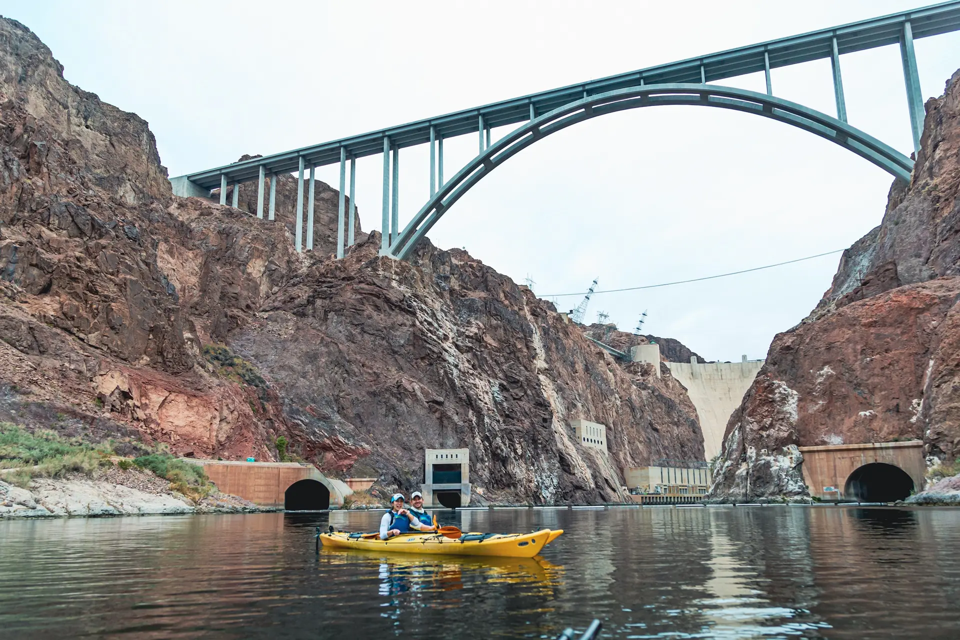 Tandem kayak paddling beneath the Hoover Dam bypass bridge